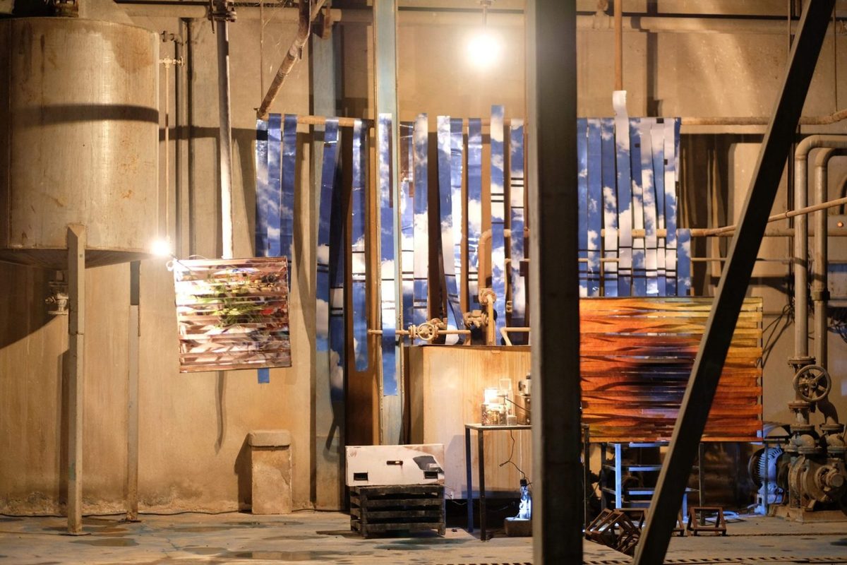 Printed works installed among the pipes and tanks of an industrial hall